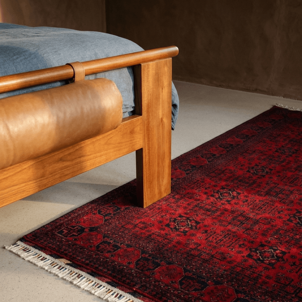 A red handwoven rug in a lived-in room